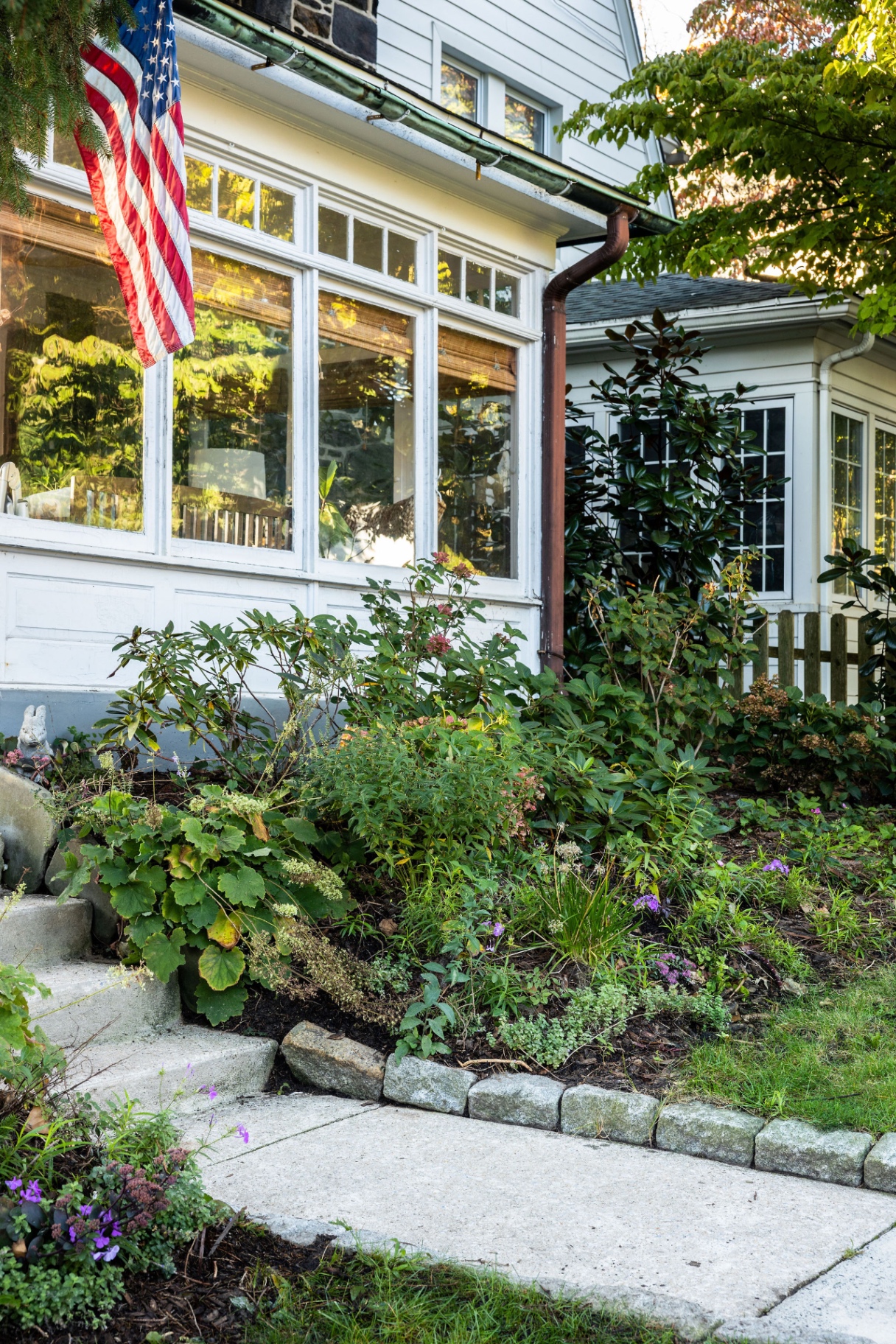 Native border with stone edging beneath the sunroom windows