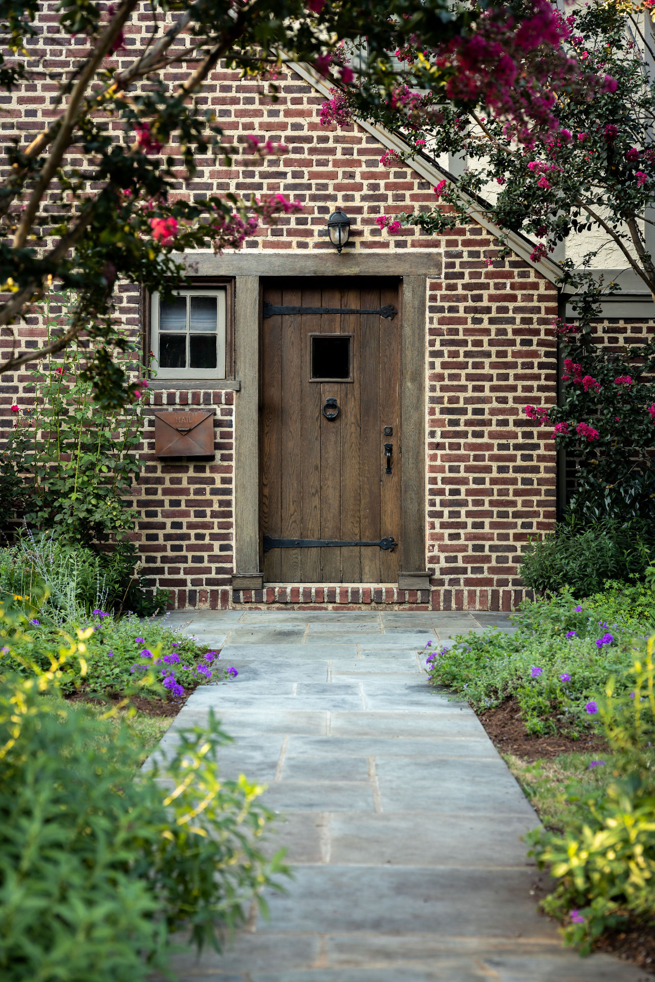 Bluestone path leading to the wood door in the brick entry building